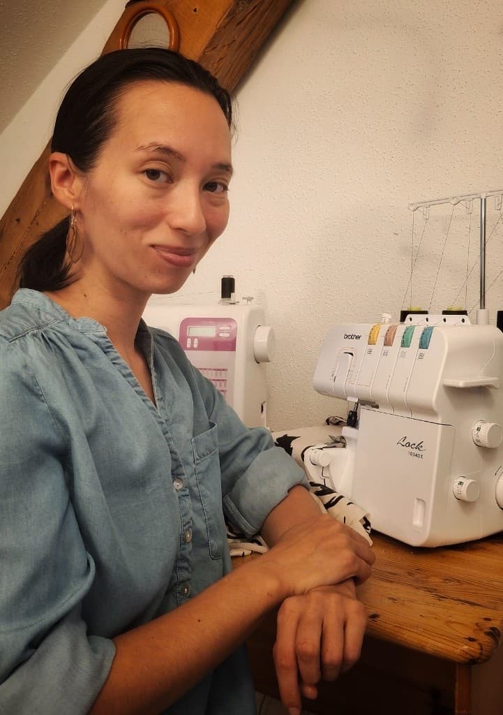 Viktoria at her sewing table with a serger and sewing machine